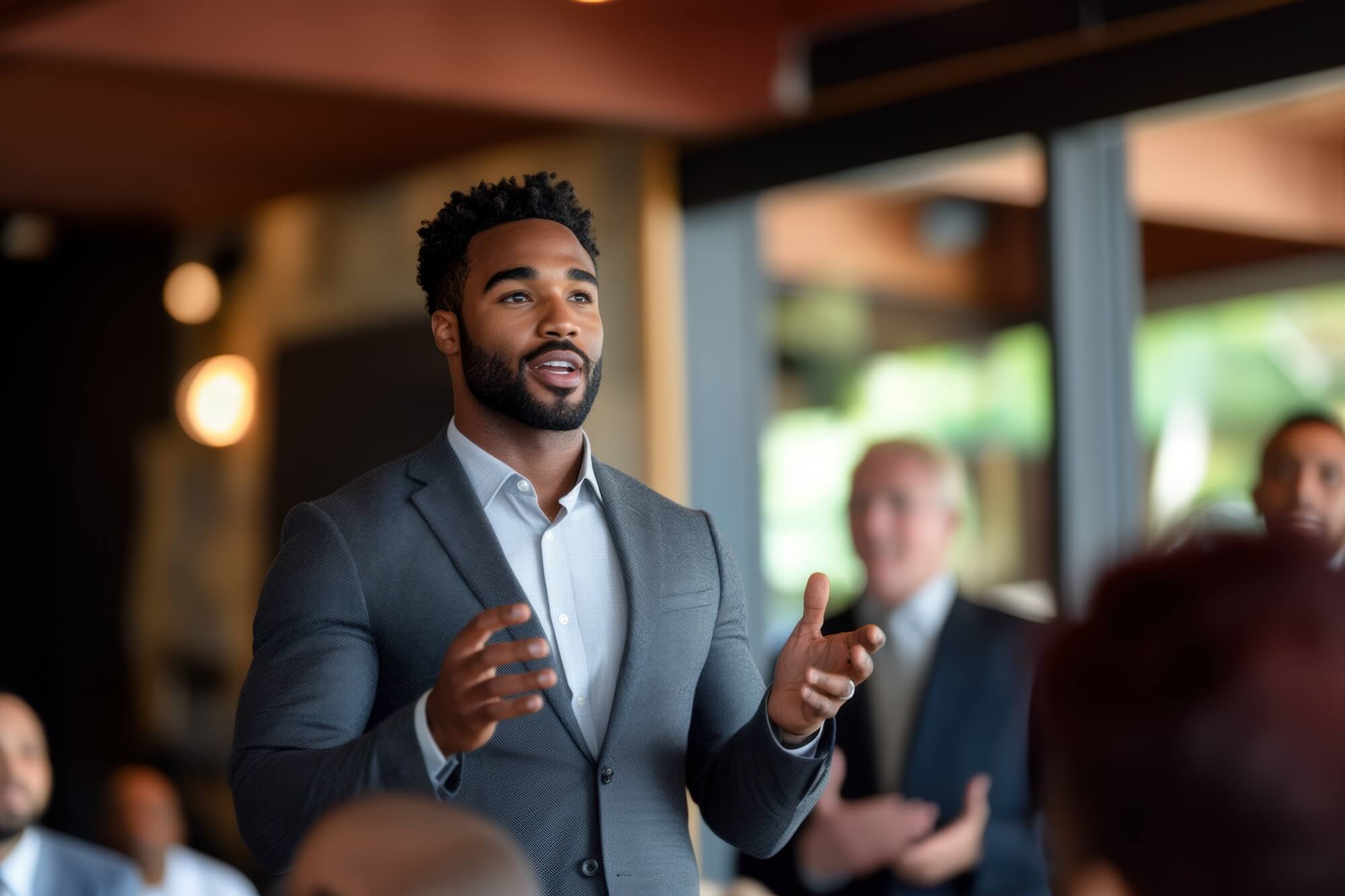 confident young business professional speaking to group in corporate setting